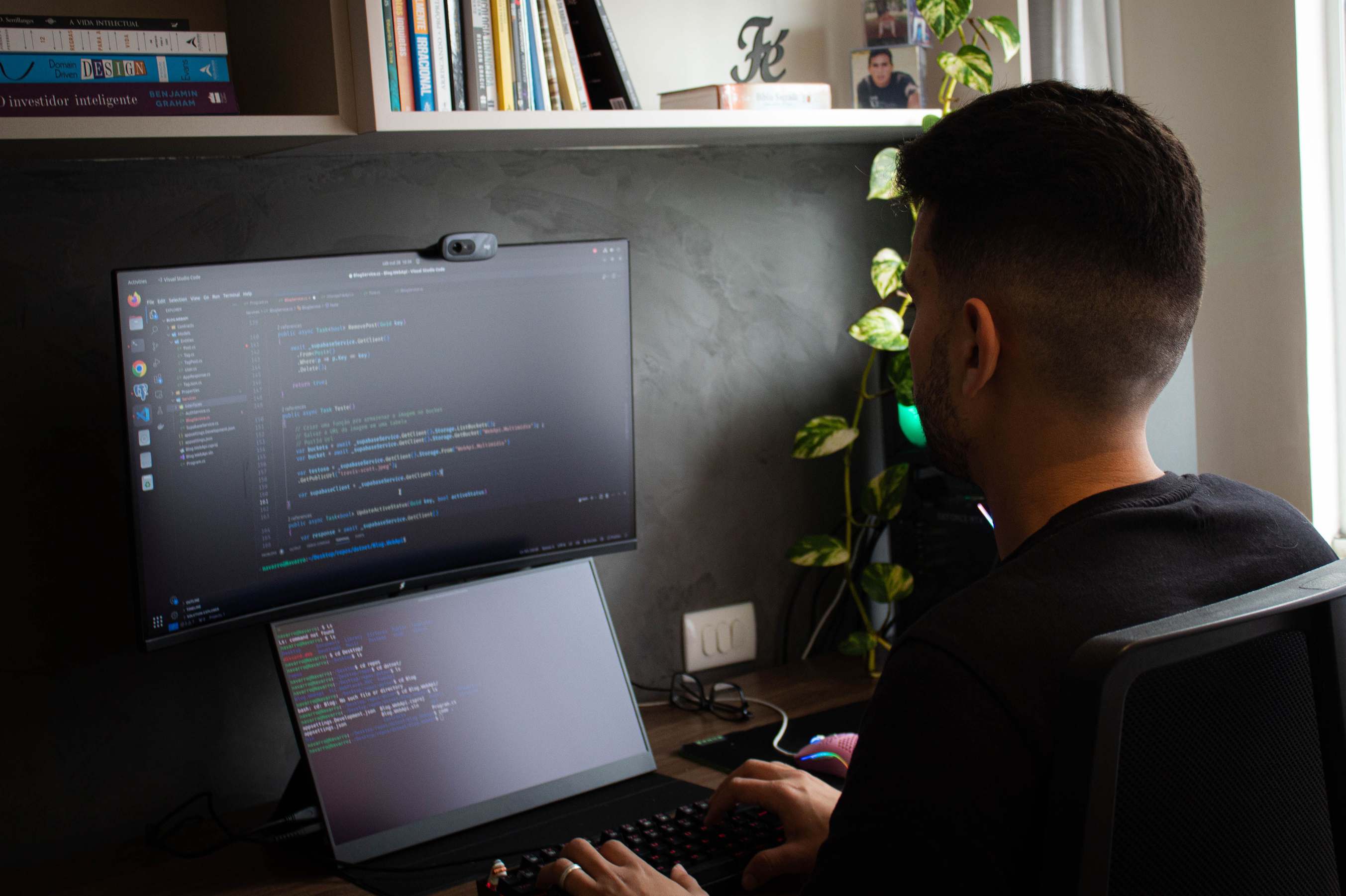 Overhead view of a laptop with code on screen beside a monitor in a stylish office setup