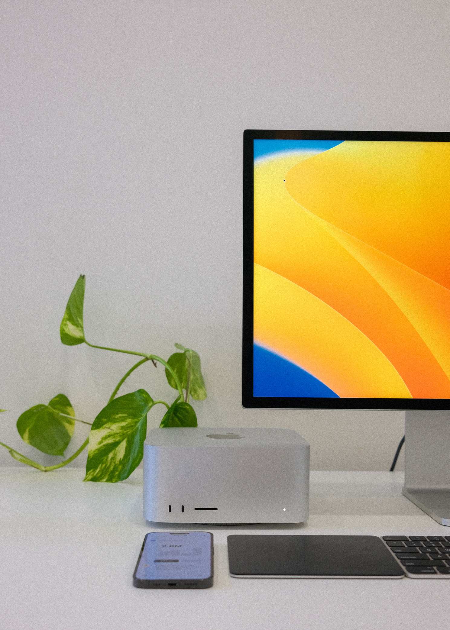 Candid view of a technology workspace with computers, monitor, smartphone, and minimalist setup